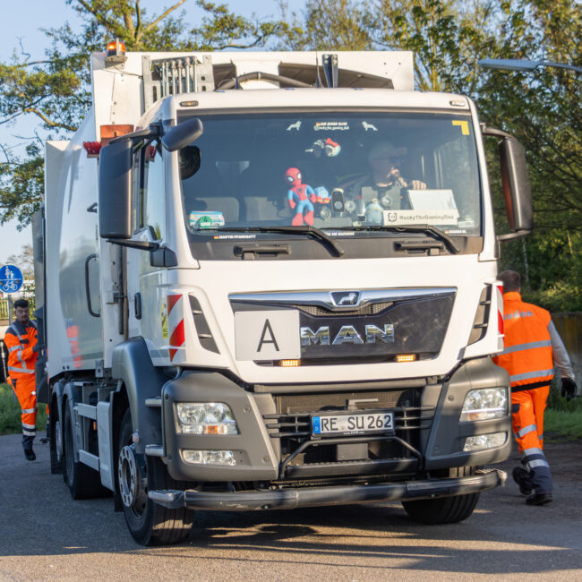 Suden Müllsammel-LKW mit Mitarbeitern bei der Arbeit